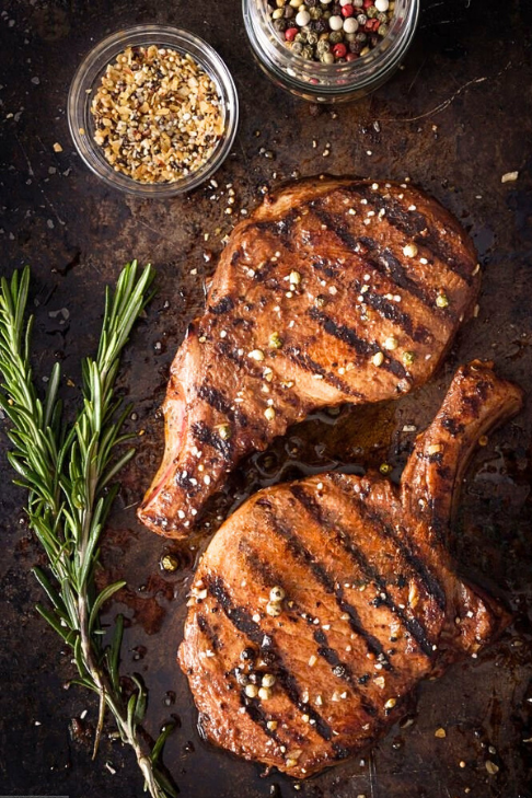 Grilled bone-in pork chops seasoned with cracked pepper and herbs